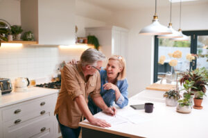 A senior woman laughs with her husband after having refractive lens exchange surgery.