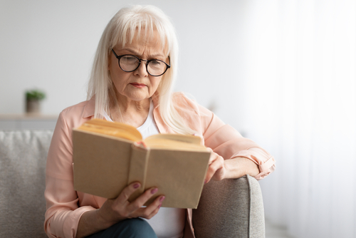 Senior man struggling to read phone, before seeking cataract lens replacement