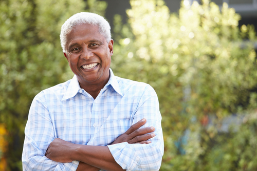 Confident senior woman smiling outdoors against blurred background, embracing freedom after eye procedure