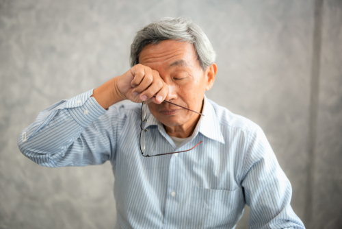 Joyful elderly man laughing with cane, recovering actively after cataract procedure