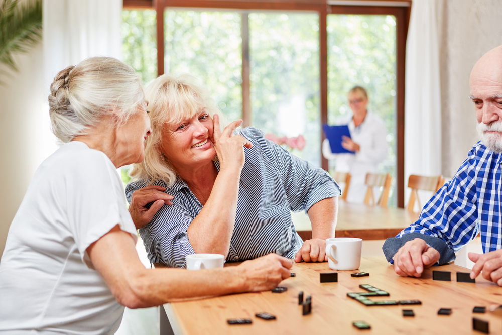 Group of seniors playing dominoes at cafe table, engaging in social activities with restored sharp vision