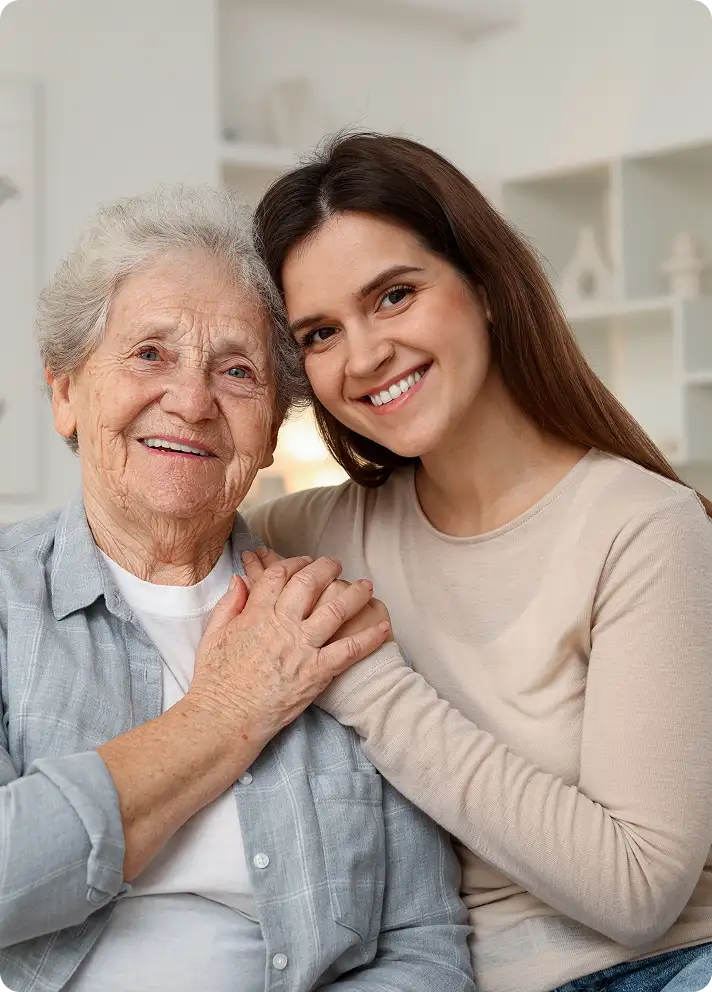Grandmother and granddaughter embracing on sofa – generational love post-cataract surgery vision.