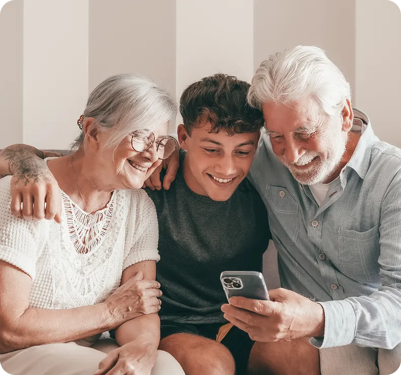 Happy multi-gen family on sofa viewing phone – joyful clear vision with Neurolens post-cataract surgery.