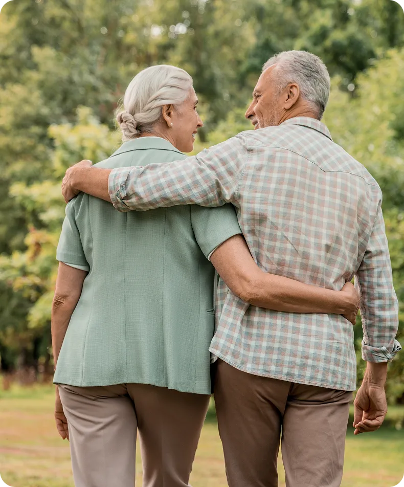 Seniors arm-in-arm park stroll – eye strain relief with Neurolens for comfortable vision.