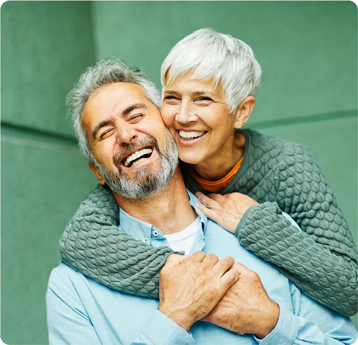 A man laughs with his wife after undergoing cataract surgery.
