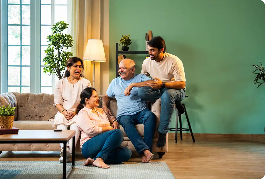 Laughing Indian family in green room – active life with clear vision after cataract procedure.