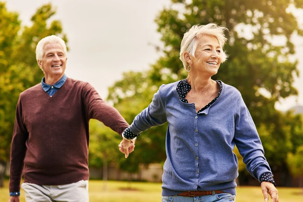 Senior man cycling energetically on forest trail, outdoor recreation enabled by clear eyesight