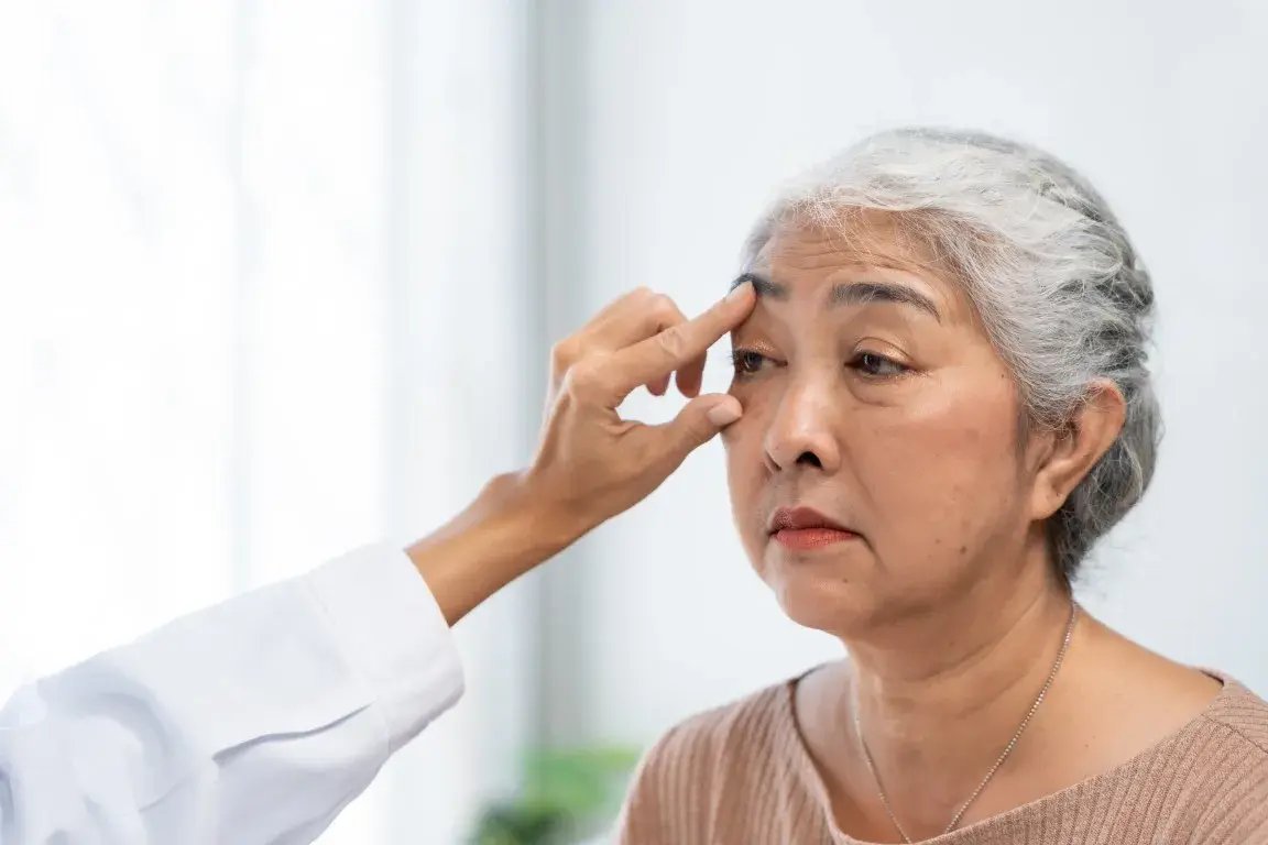 An ophthalmologist examines an older woman’s eye during a cataract surgery second-opinion consultation.